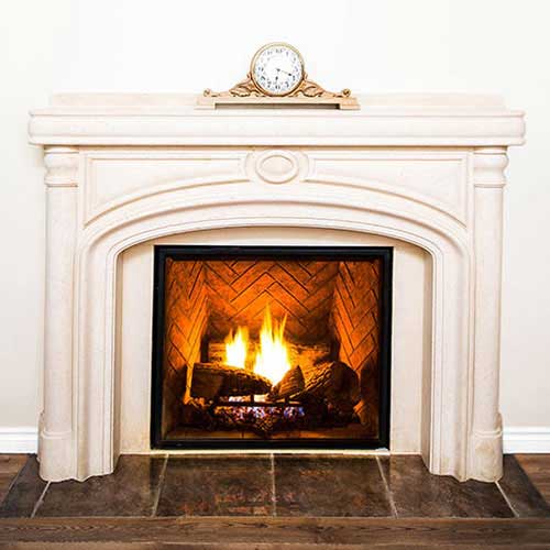 White hearth around wood burning fireplace with clock on top of hearth and tile floor in front
