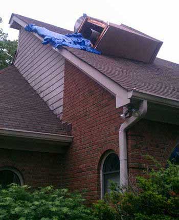 Chimney on roof of home that has been destroyed blue plastic tarp on the roof next to it
