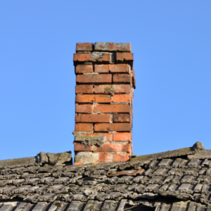 a broken down and damaged red brick masonry chimney